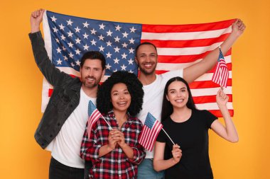 4 Temmuz - ABD 'nin Bağımsızlık Günü. Sarı arka planda Amerikan bayrakları olan mutlu arkadaşlar