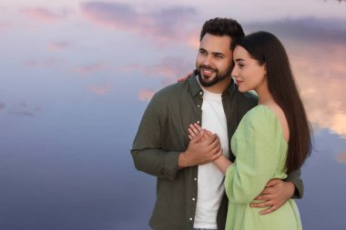 Romantik bir randevu. Güzel bir çift göl kenarında vakit geçiriyor, mesaj için yer var.