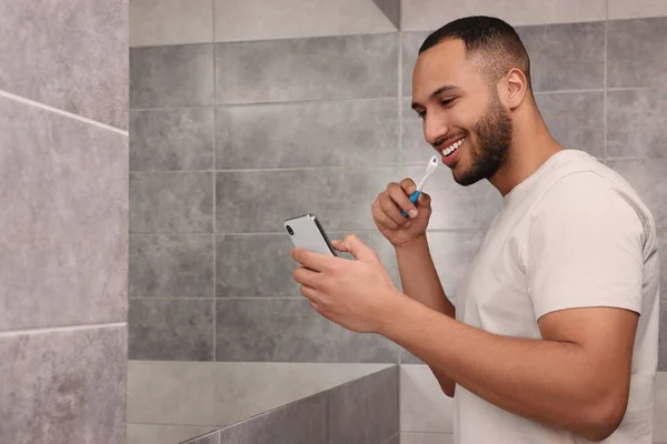 Glücklicher Mann Mit Smartphone Beim Zähneputzen Badezimmer Platz Für Text — Stockfoto
