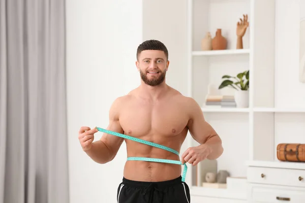 一个快乐的运动员在家里用带子测量腰围的画像 体重减轻概念 — 图库照片