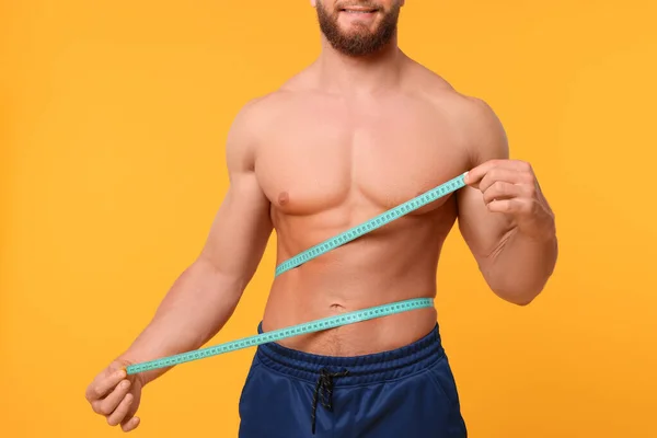 Atletische Man Meten Taille Met Tape Oranje Achtergrond Close Gewichtsverlies — Stockfoto