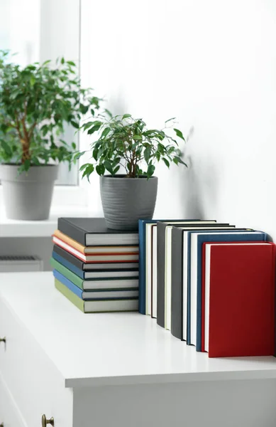 Viele Verschiedene Bücher Und Topfpflanzen Auf Weißem Schrank Drinnen — Stockfoto