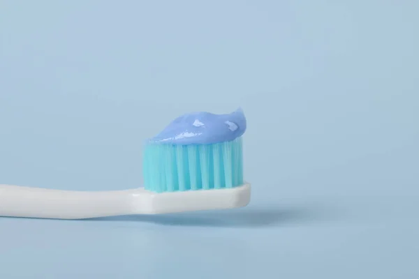 Plast Tandborste Med Pasta Ljusblå Bakgrund Närbild — Stockfoto
