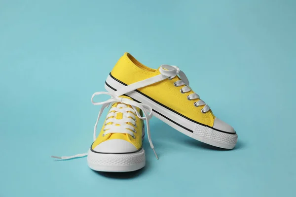 浅蓝色底色黄色经典旧式运动鞋的搭配 — 图库照片