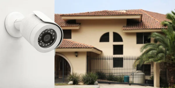 Stock image Home security camera on wall against house on street, closeup