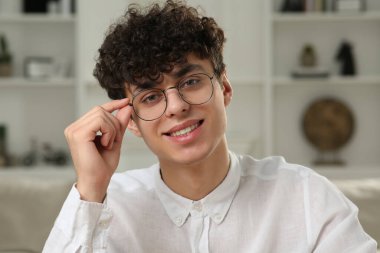 Genç adam evde video görüşmesi yapıyor, web kamerasından görüntü alıyor.