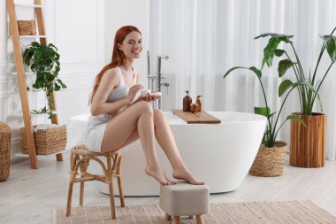 Banyoda vücut kremi olan güzel genç bir kadın, mesaj atmak için yer var.