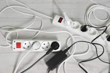 Beyaz zeminde farklı elektrik prizleri olan elektrik şeritleri düz yerde.