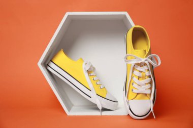 Turuncu arka planda sarı klasik eski moda spor ayakkabıları sunumu