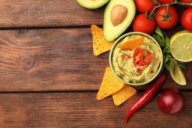 Bir kase lezzetli guacamole, cips ve ahşap masa malzemesi. Metin için boşluk