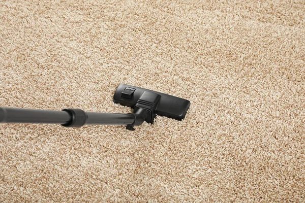 用现代真空吸尘器去除米黄色地毯上的灰尘 — 图库照片