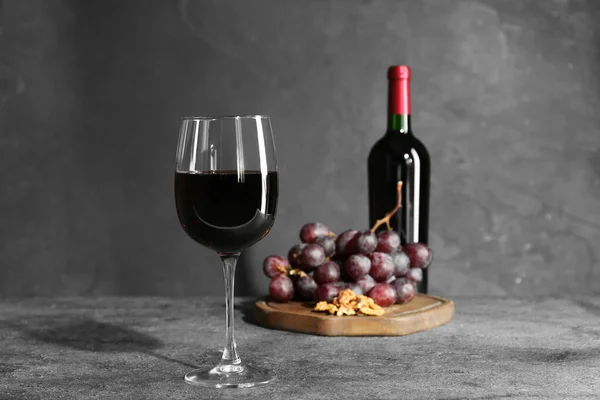 Glas Rode Wijn Fles Noten Druiven Grijze Tafel Stockfoto