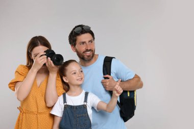 Mutlu aile açık gri arka planda fotoğraf çekiyor. Metin için boşluk