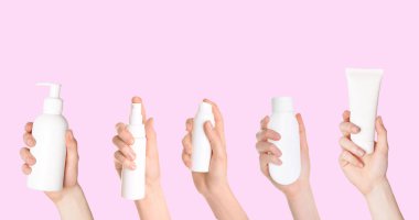 Kadınların elinde şişeler ve pembe arka planda farklı kozmetik ürünlerden oluşan tüpler var. Kolaj tasarımı