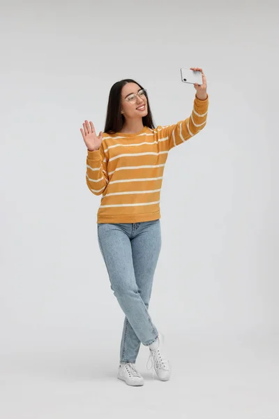 Χαμογελαστή Νεαρή Γυναίκα Που Παίρνει Selfie Smartphone Λευκό Φόντο — Φωτογραφία Αρχείου