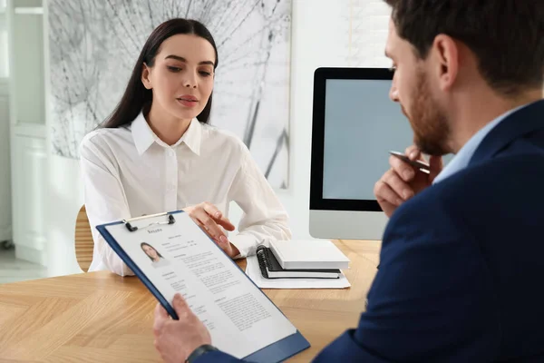 stock image Human resources manager reading applicant's resume in office