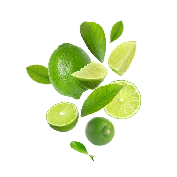 Verse Limoenvruchten Groene Bladeren Die Witte Achtergrond Vallen — Stockfoto