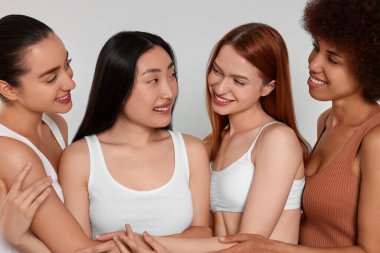 Açık gri arka planda güzel genç kadınların portresi