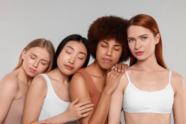 Açık gri arka planda güzel genç kadınların portresi