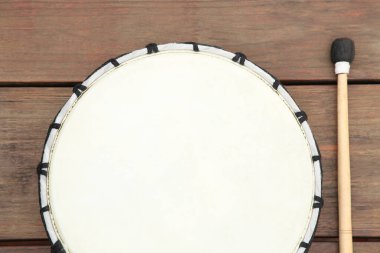 Ahşap masa üzerinde bageti olan modern davul, düz yatıyordu. Perküsyon müzik aleti