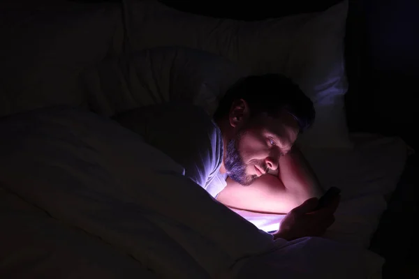 Мужчина Использующий Смартфон Ночью Постели Интернет Зависимость — стоковое фото