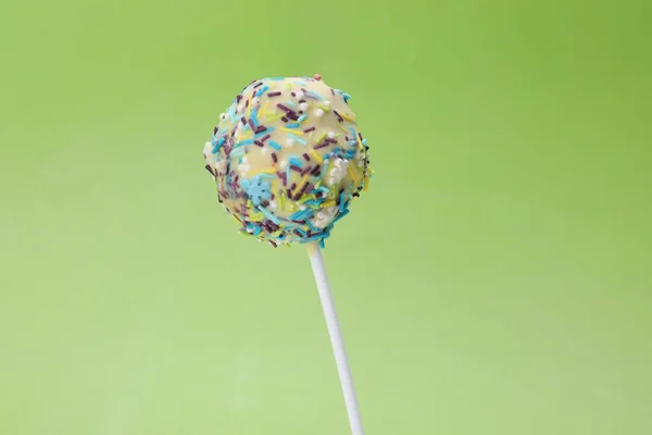 Pyszne Słodycze Słodkie Ciasto Pop Ozdobione Posypką Jasnozielonym Tle Zbliżenie — Zdjęcie stockowe