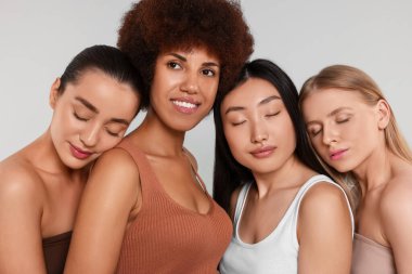 Açık gri arka planda güzel genç kadınların portresi