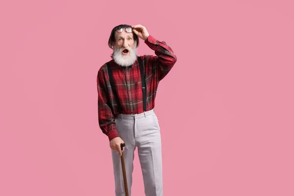 Överraskad Senior Man Med Promenadkäpp Rosa Bakgrund — Stockfoto