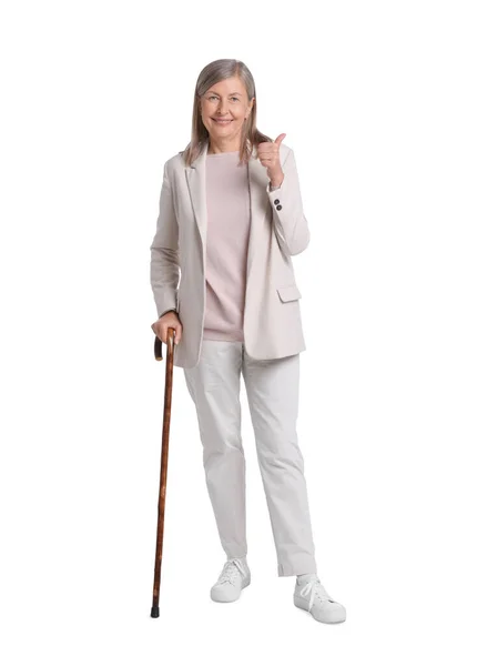 上了年纪的女人 拿着手杖 在白色的背景上竖起大拇指 — 图库照片