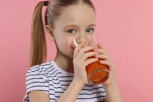 小女孩在粉红的背景下喝新鲜果汁 — 图库照片