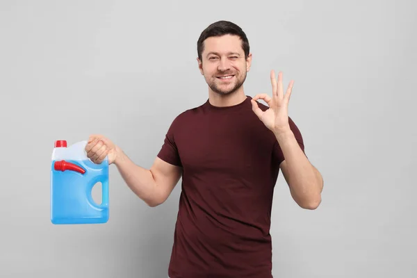 Hombre Sosteniendo Bote Con Líquido Azul Mostrando Gesto Sobre Fondo —  Fotos de Stock