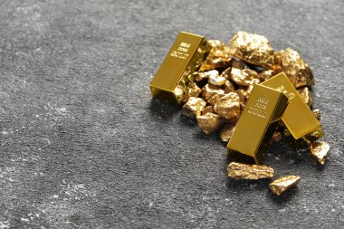 Altın külçeler ve külçeler gri masada. Metin için boşluk