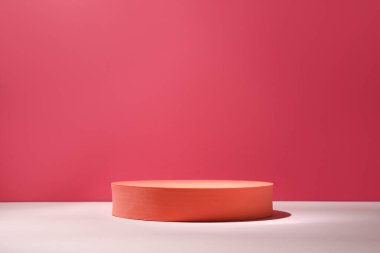 Pembe arka plana karşı masada duran turuncu masa, mesaj için yer var. Ürün için stil sunumu