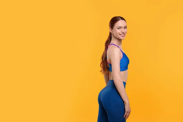 Sarı Arka Planda Spor Giyinen Genç Bir Kadın Mesaj Için — Stok fotoğraf