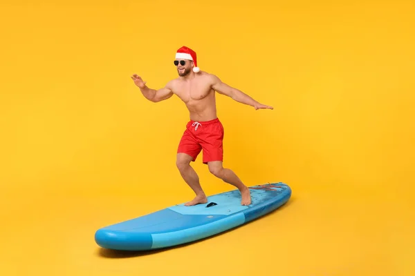 Homem Feliz Papai Noel Balanceamento Sup Bordo Contra Fundo Laranja — Fotografia de Stock