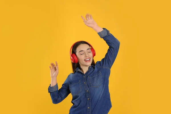 Gelukkig Vrouw Hoofdtelefoon Luisteren Muziek Dansen Oranje Achtergrond — Stockfoto