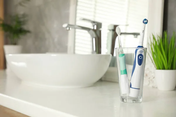 Electric Toothbrushes Glass Vessel Sink Bathroom Vanity Space Text — Stock Photo, Image