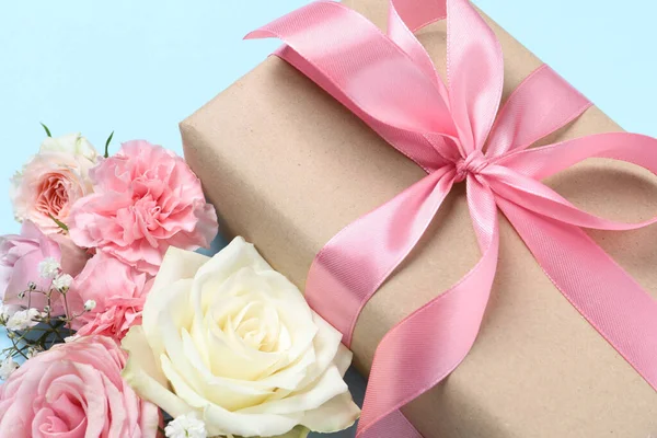 Geschenk Box Und Schöne Blumen Auf Hellblauem Hintergrund Nahaufnahme — Stockfoto