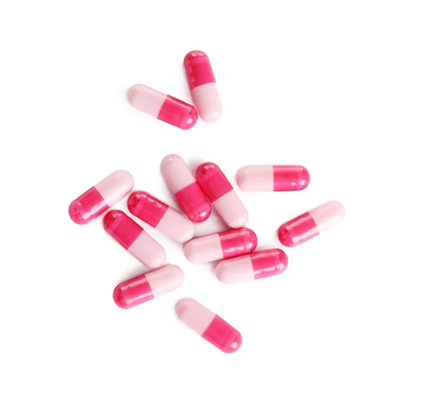 许多粉色药丸隔离在白色的顶部视图 — 图库照片