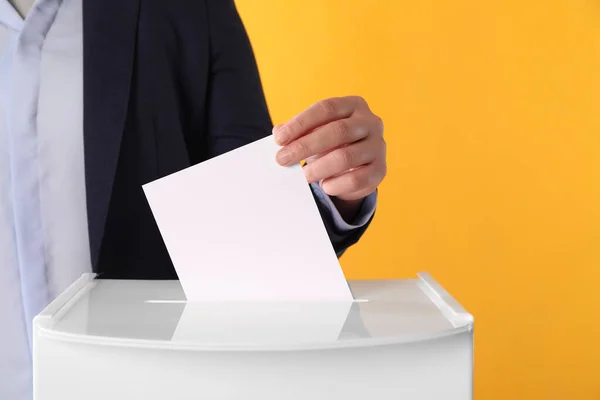 Frau Gibt Ihre Stimme Die Wahlurne Auf Orangefarbenem Hintergrund Nahaufnahme — Stockfoto