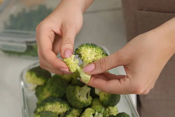 Mujer Poniendo Brócoli Verde Recipiente Con Verduras Frescas Primer Plano — Foto de Stock