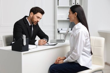 İş görüşmesi sırasında başvuranın özgeçmişini okuyan insan kaynakları yöneticisi