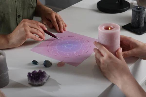 stock image Astrologer predicting client's future with natal chart at table, closeup