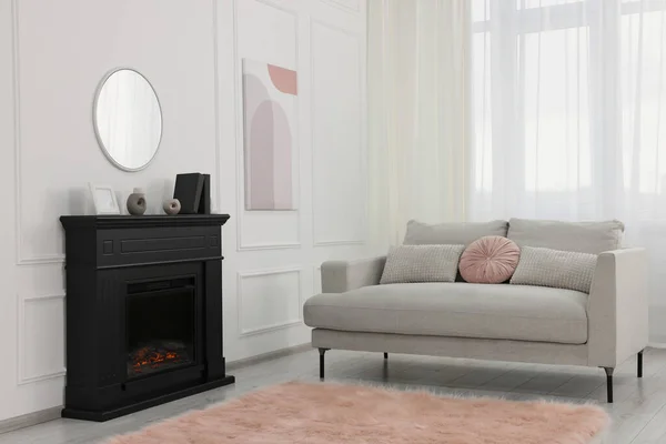 舒适的客厅里舒适的沙发旁边的黑色时尚壁炉 — 图库照片
