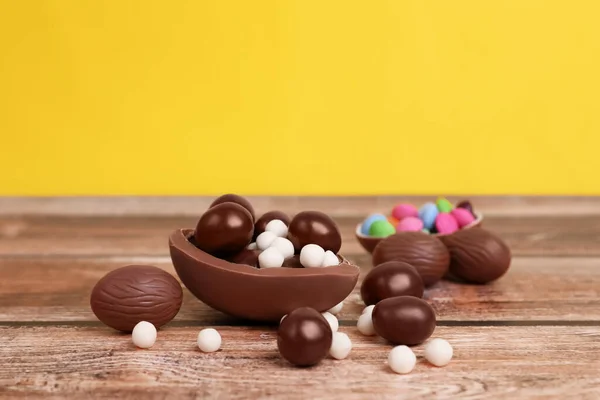 Deliciosos Huevos Chocolate Caramelos Sobre Mesa Madera Sobre Fondo Amarillo — Foto de Stock