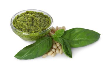 Lezzetli pesto sosu, çam fıstığı ve fesleğen yaprakları beyaz üzerine izole edilmiş.