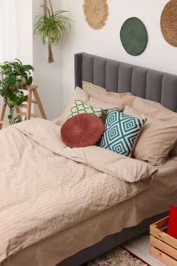 Büyük, rahat bir yatak odası ve şık bir yatak odasında saksı çiçekleri. İç tasarım