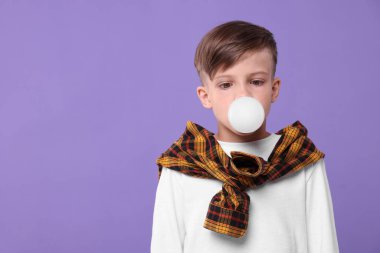 Çocuk mor arkaplanda sakız üflüyor, mesaj için boşluk