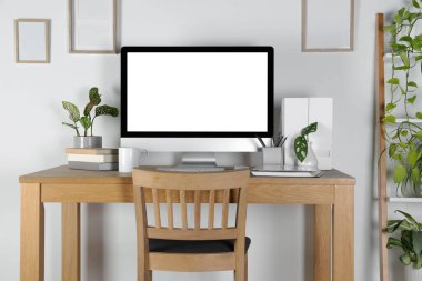 Ev işyerinde. Bilgisayar, kırtasiye ve ev bitkileri ahşap masada.