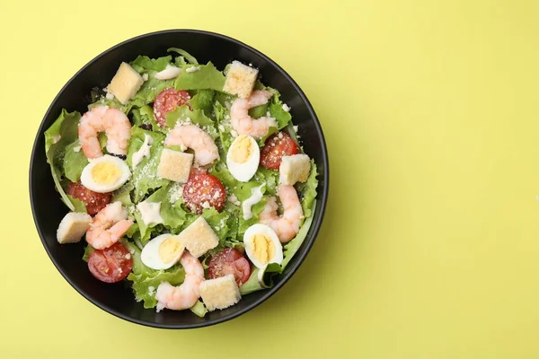 stock image Delicious Caesar salad with shrimps on yellow background, top view. Space for text